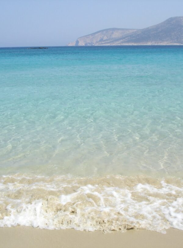 Turquoise crystal-clear beach waters at Ano Koufonisi, Greece on a sunny summer day
