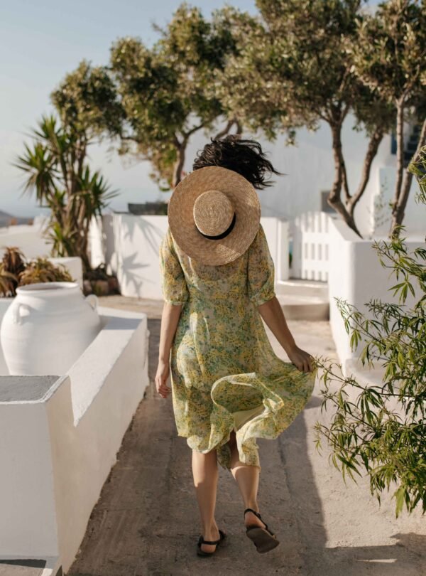 Woman enjoying a sunny sea-view terrace in Naxos, Greece with traditional Cycladic architecture